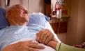 Old man lying in hospital bed holding daugher Faith leaders oppose changes to MAID law