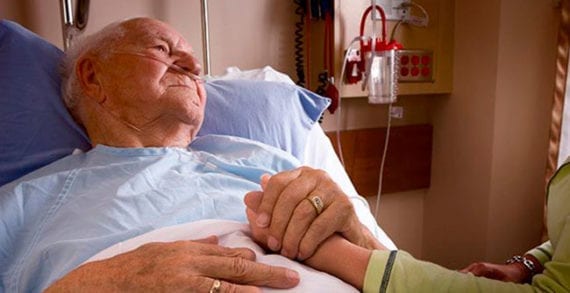 Old man lying in hospital bed holding daugher What happens when a hospice rejects medical assistance in dying?