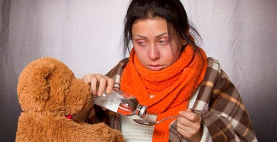 Young woman taking flu medication Antibiotics no cure for colds or flu